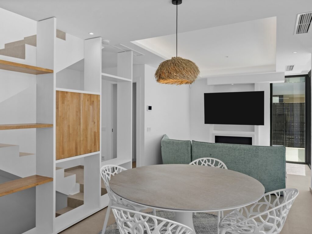 Open-plan dining area with oak shelving and fireplace